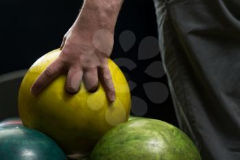 Holding Ball Against Bowling Alley