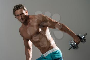 Mature Man Working Out Triceps - Dumbbell Concentration Curls On Grey Background