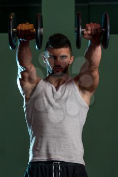Muscular Men Exercising Shoulder With Dumbbells