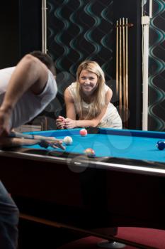 Young Couple Playing Pool Together