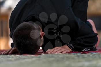 Young Muslim Man Making Traditional Prayer To God While Wearing A Traditional Cap Dishdasha