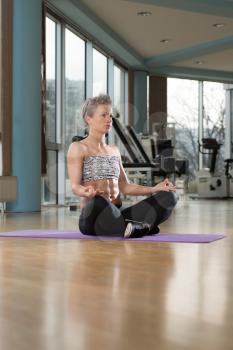 Woman Meditating In A Health Club Doing Yoga