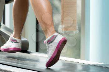 Close-Up Of Female Legs Running On Treadmill - Blurred Motion