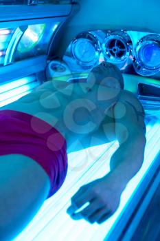 Young Muscular Man At Solarium In Beauty Salon