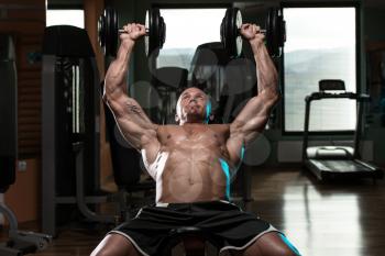 Handsome Young Man Doing Dumbbell Incline Bench Press Workout In Gym