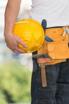 Close-Up Of Hard Hat Holding By Construction Worker