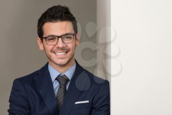 Portrait Of Handsome Confident Young Businessman Standing Arms Crossed