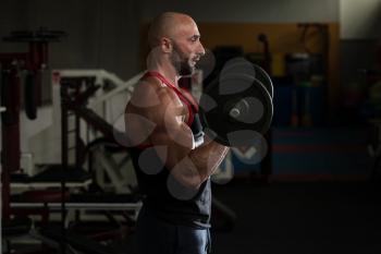 Mature Man Working Out Biceps In A Health Club