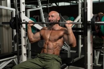 Mature Man Doing Shoulder Exercises In The Gym