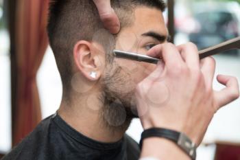 Handsome Young Hairdresser Giving A New Haircut To Male Customer At Parlor