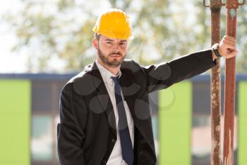 Portrait Of Business Man With Yellow Helmet On Construction