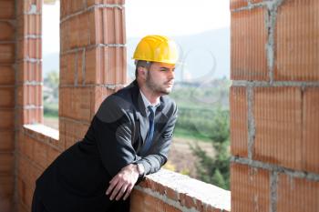 Portrait Of Business Man With Yellow Helmet On Construction