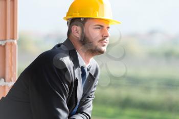 Portrait Of Business Man With Yellow Helmet On Construction