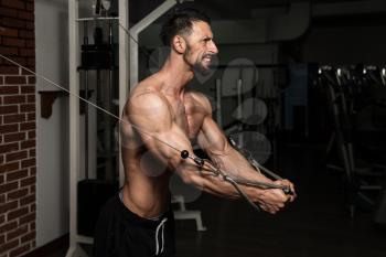 Bodybuilder Is Working On His Chest With Cable Crossover In A Dark Gym