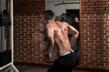 Bodybuilder Doing Heavy Weight Exercise For Back On Machine