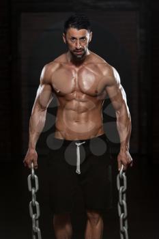 Portrait Of A Physically Fit Man Showing His Well Trained Body And Holding Chains
