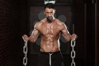 Healthy Bodybuilder Exercising Biceps With Chains