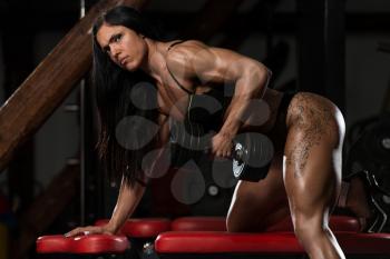Young Woman In Underwear Doing Heavy Weight Exercise For Back With Dumbbell