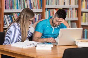 Stressed Students In High School Sitting At The Library Desk - Shallow Depth Of Field