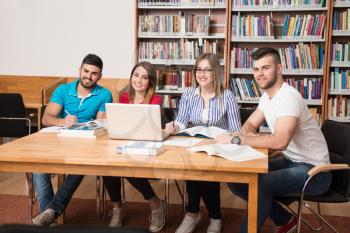 In The Library - Handsome Group Of Students With Laptop And Books Working In A High School - University Library - Shallow Depth Of Field