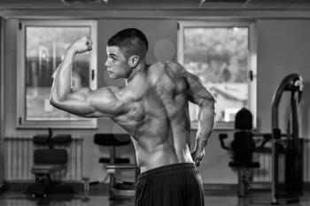 Portrait Of A Physically Fit Man Showing His Well Trained Body In Gym