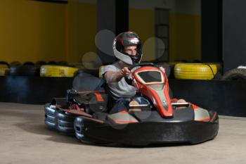 Young Man Is Driving Go-Kart Car With Speed In A Playground Racing Track - Go Kart Is A Popular Leisure Motor Sports