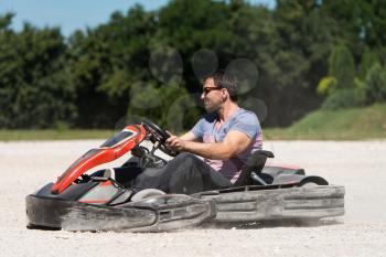 Young Man Is Driving Go-Kart Car With Speed In A Playground Racing Track - Go Kart Is A Popular Leisure Motor Sports