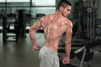 Awesome Bodybuilder Showing His Muscles And Posing In Gym