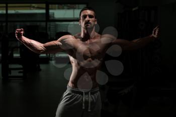 Athlete Muscular Brutal Bodybuilder Emotional Posing In A Dark Gym