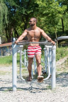 Handsome Muscular Young Man - Training On The Playground In Park