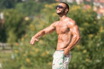 Portrait Of A Physically Fit Man Showing His Well Trained Body Outdoors In Summer Time