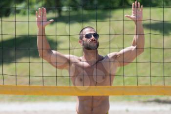 Muscular Young Man Playing Beach Volleyball Diving After The Ball