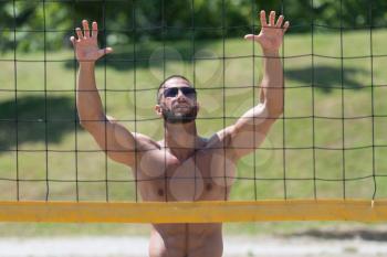 Muscular Young Man Playing Beach Volleyball Diving After The Ball