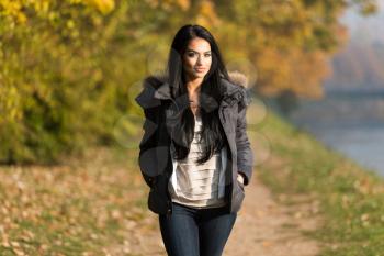 Young Woman Walking In Forest Through The Woods Outside During Autumn