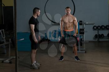 Handsome Guy Working Out Kettle Bell With Personal Trainer