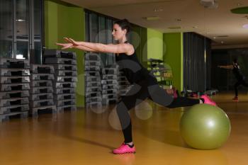 Young Woman Working Out With Ball In Fitness Center