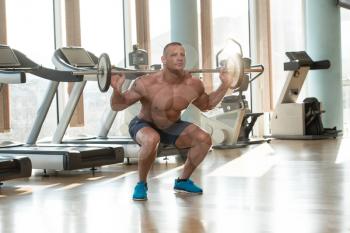 Physically Fit Man Exercising Legs By Doing Squats
