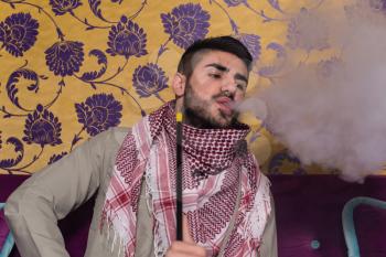 Muslim Man Smoking Turkish Hookah In The Cafe With Colorful Walls On Background