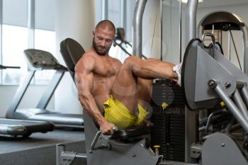 Attractive Young Man Doing Leg Press On Machine In Gym