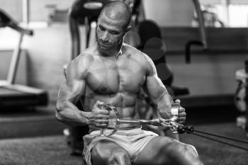 Young Bodybuilder Doing Heavy Weight Exercise For Back On Machine