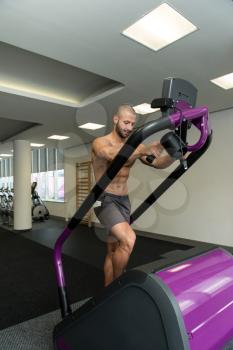 Handsome Man Exercising On A Stepper In Gym