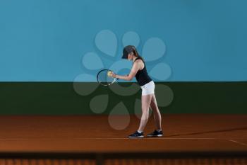 Portrait Of Female Tennis Player With Racket Ready To Serves Toss Ball