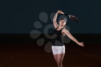 Portrait Of Female Tennis Player With Racket Ready To Hit A Tennis Ball