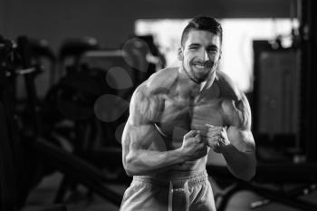 Young Man Standing Strong In The Gym And Flexing Muscles - Muscular Athletic Bodybuilder Fitness Model Posing After Exercises