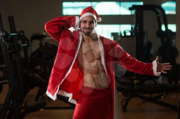 Young Muscled Man In Santa Claus Outfit Posing In A Fitness Center Gym