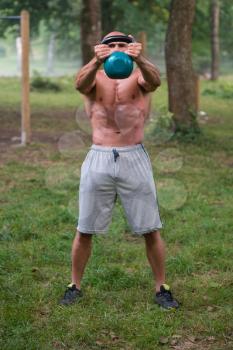 Fitness Man Lifting Kettlebell Workout Exercise Outdoors In Nature