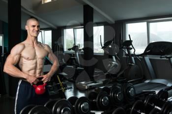 Young Man Working With Kettle Bell In A Gym