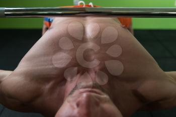 Close-Up Of A Young Man In Gym Exercising Chest On The Bench Press