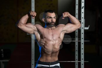 Portrait Of A Young Fit Man Showing Front Double Biceps Pose - Muscular Athletic Bodybuilder Fitness Model Posing After Exercises