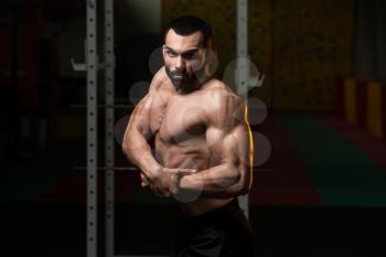Portrait Of A Young Physically Fit Man Performing Side Chest Pose - Muscular Athletic Bodybuilder Fitness Model Posing After Exercises